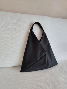 the satin origami bag is the perfect minimalist black bag for your essential belongings, this size holds cell phone, wallet, a small makeup pouch, sunglasses and keys. you can use it for you nights out with friends, as evening bag in more formal occasions or as modern minimal daily shoulder bag. the triangle bag is handmade from black polyester satin, this fabric is satin not glossy. the handle is from the same black satin of the bag. interior lining is in black polyester light satin fabric. you can wear the purse over the shoulder or by hand. approximate measures: width 40 cm, at bottom.  height 48 cm, from top handle to bottom of the bag. ( 15.7 x 19 inches ) the minimalist Japan style bag is soft and lightweight. easy to fold and convenient to insert in your weekender so to have a styli Origami Triangle, Bag Origami, Small Makeup Pouch, Origami Bag, Bag Minimalist, Triangle Bag, Black Evening Bag, Satin Noir, Bag Interior