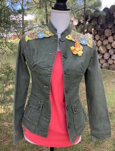 Women's green denim jacket, fitted, back peplum embellished with embroidered tulle of yellow, blue and green flowers and eaves. I have also added a vintage enameled yellow flower with green stem. Size extra-small, measures 16" across chest with button closed.  This would make a beautiful gift for the woman who likes unique, one-of-kind pieces!  Spot clean only!! Fitted Denim Jacket For Spring, Vintage Cotton Outerwear For Spring, Fitted Floral Print Denim Jacket, Green Cotton Denim Jacket With Pockets, Green Denim Jacket With Pockets For Spring, Green Summer Outerwear With Buttons, Fitted Denim Jacket With Floral Embroidery For Summer, Spring Fitted Denim Jacket With Pockets, Spring Cotton Outerwear With Floral Applique