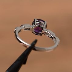 It is a natural amethyst ring. The main stone is 7mm*7mm round cut, weight about 1.25 carats. The basic metal is sterling silver and plated with rhodium. To change the metal to a solid gold (white/rose) or platinum is also available, please ask for a quotation if you want. You can also go to my shop Home for more elegant rings: https://www.etsy.com/shop/godjewelry?ref=hdr_shop_menu Amethyst is February birthstone. Customization is always welcome and please feel free to contact with me if you hav Engagement Ring Silver, February Birthstone Ring, Round Cut Engagement Ring, Elegant Rings, Rings Gemstone, Purple Amethyst Ring, Round Cut Engagement Rings, February Birthstone, Elegant Ring