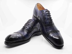 Style: 5817-1233A-Navy Exclusively for C & E, this Completely Handmade, Hand Burnished Genuine Alligator lace-up oxford from the Ugo Vasare collection features Goodyear Welted construction, soft Calfskin lining, a Cap Toe, Decorative Perforations with Pinking Detail, a stitched welt and a full Leather sole! Please note: Some sizes are on Back Order. Luxury Crocodile Pattern Oxfords, Classic Fitted Oxfords With Crocodile Pattern, Formal Fitted Oxfords With Crocodile Pattern, Luxury Fitted Oxfords For Galas, Elegant Fitted Oxfords With Laces, Luxury Crocodile Pattern Oxfords For Semi-formal Events, Luxury Crocodile Pattern Oxfords For Semi-formal Occasions, Fitted Oxfords For Galas, Lace-up Oxfords For Galas