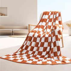 an orange and white checkered blanket sitting on top of a chair