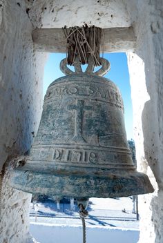 an old bell is hanging in the snow