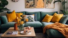 a living room with green couches and yellow throw pillows on the coffee table in front of it