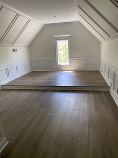 an empty room with hard wood floors and white walls