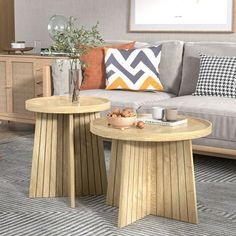 two wooden tables sitting on top of a rug in a living room next to a couch