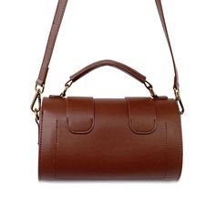 Our Mini Coffee Barrel Hand Bag is a small cross-body piece that is truly understated! Its carries a dated vintage tone that takes you on a journey that can be translated to both season-less and glamorous. 100% Genuine Leather Double rotary fasteners Open internal compartment with single rear wall pocket Adjustable and Removable shoulder strap Bright gold hardware 8" (L) x 4"(W) x 6"(H) Small Crosses, Bright Gold, Wall Pockets, Hand Bag, Gold Hardware, Cross Body, Barrel, Top Handle Bag, Shoulder Strap