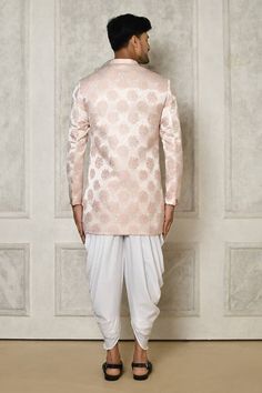 Rose gold sherwani with all over foral butti pattern. Paired with a white dhoti pant.
Components: 2
Pattern: Woven
Type Of Work: Floral Butti
Neckline: Stand Collar
Sleeve Type: Full Sleeves
Fabric: Sherwani: Jaquard, Dhoti Pant: Cotton
Color: Gold,Pink
Other Details: 
Closure: Front buttons
Embellished brooch detailing
Asymmetric hem
Occasion: Sangeet,Wedding - Aza Fashions Sherwani With Dhoti, Gold Sherwani, Dhoti Pants For Men, Dhoti Pants, Buy Gold, Full Sleeves, Asymmetric Hem, Aza Fashion, Full Sleeve