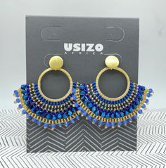 Embrace the beauty of tradition & contemporary design as these stunning "African Goddess" earrings effortlessly blend the past & present. Intricate beadwork reflects the rich history of the Zulu people while the modern twist brings style & elegance to this design. 2.7"W x 2.5"L Stainless steel studs with 18k gold plated finish. Blue Fusion Style Jewelry For Celebration, Blue Dangling Beads Earrings For Celebration, Beaded Earrings For Festivals And Celebrations, Beaded Earrings For Celebrations And Festivals, Festive Earrings With Gold Beads, Blue Dangling Beads Jewelry For Festivals, Traditional Blue Beaded Earrings, Bohemian Earrings With Colorful Beads For Celebration, Blue Dangling Beads Earrings For Festive Occasions