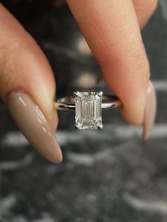 This stunning diamond engagement ring features a sparkling 2 carat Emerald Cut lab grown diamond, certified by IGI as having a magnificent E color and VVS2 clarity. The classic emerald cut is a timeless choice, with its elongated shape and broad facets that maximize the brilliance and fire of the diamond, this ring is the perfect choice for anyone looking for a ring that truly displays elegance and beauty. Handcrafted from high-quality 14k Gold, this solitaire ring is available in White Gold, Yellow Gold or Rose Gold. IGI Certified CVD Lab Grown Diamond Diamond Cut: Emerald Carat Weight: 2 Carat Color: E Clarity: VVS2 Ring Metal: 14k Gold Original IGI Certificate included 30 day full money back guarantee, 100% satisfaction guaranteed! Solitaire Emerald Cut Engagement Ring White Gold, White Emerald Engagement Ring, Large Radiant Cut Engagement Ring, 3 Carat Emerald Engagement Ring, Emerald Cut Engagement Ring 2 Carat, Rectangle Emerald Engagement Ring, White Gold Engagement Rings Emerald Cut, Emerald Engagement Ring Platinum, Emerald White Gold Engagement Ring