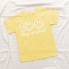 Looking for a cute tee for your kids? We have the perfect 100 Days Of School Smiley Face graphic tee addition to their closet! Also available in youth tees. Playful Funny Print T-shirt For School, Fun Slogan T-shirt For School, Playful Summer T-shirt For School, Fun Letter Print T-shirt For End Of School Year, Playful T-shirt For School In Spring, Spring School T-shirt With Slogan, End Of School Year Fun T-shirt With Letter Print, Fun Slogan Tops For School, Playful Graphic Print T-shirt For Daycare