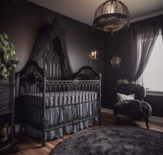 a baby crib in a dark room with a chandelier above it and a black rug on the floor