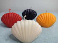 three seashell shaped candles sitting on top of a table