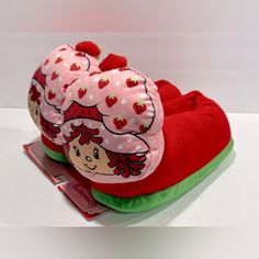 two strawberry shorties are sitting on top of each other, one is wearing a pink hat and the other has a green bottom