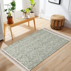 a living room area with wooden floors and white rugs on top of the floor