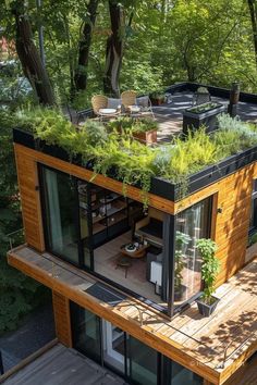 a house with plants growing on the roof and balcony area, surrounded by greenery