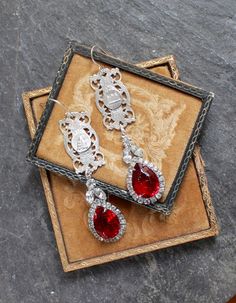 "The elaborate Paris components in these gorgeous earrings are salvaged from an antique France souvenir bracelet. The red and clear rhinestone drops are from a pair of mid 1900's earrings, and are a perfect complement to these lovely bracelet elements. The images on the bracelet links are the Opera House and the cathedral of the Sacred Heart of Montmartre. These are so beautiful with just about anything you would wear by they do make an elegant statement with a formal dress. They would also dres Ornate Red Teardrop Jewelry, Red Filigree Dangle Jewelry, Red Dangle Filigree Jewelry, Ornate Red Drop Earrings, Vintage Red Jewelry With Rhinestones, Victorian Jeweled Earrings Gift, Vintage Red Teardrop Jewelry, Vintage Rhinestone Jewelry For Gifts, Vintage Ruby Jewelry For Parties