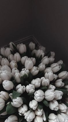 a bunch of white tulips are arranged in a circle on a table top