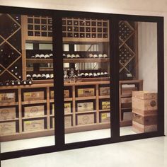 the wine cellar is full of many bottles and boxes in it's display case