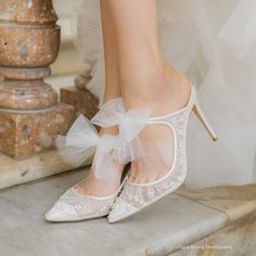 the bride's shoes are adorned with white tulle and bowknots