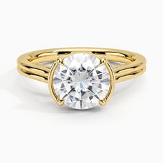 a yellow gold ring with a round cut diamond in the center and two thin bands around it