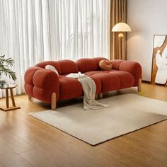 a living room with a red couch and white rug