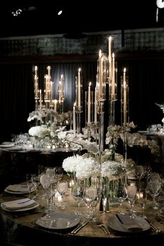 an elegant table setting with candles and flowers on the centerpieces is ready to be served