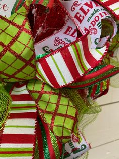 a close up of a green and red christmas bow