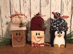 three christmas decorations made to look like snowmen and penguins with hats, scarfs and scarves