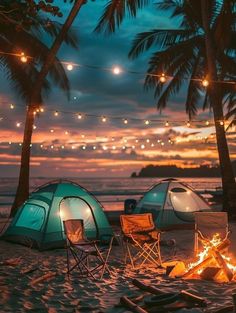 two tents are set up on the beach at night with lights strung from palm trees