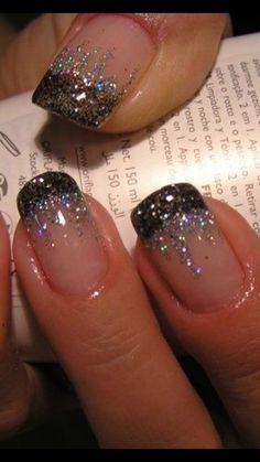 a woman's nails with glitter on them and an open book in the background