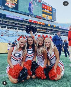 three cheerleaders pose on the field at a football game