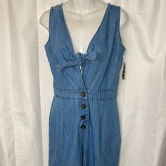 Take A Stand And Declare It. Boss Up And Step Out In This Strap Denim Jumpsuit That Is Sure To Lure Your Boo. It Features Front Buttons And A Tie-Up Top. This Romper Is A Comfortable Outfit That Can Be Worn With Heels Or High Top. Sleeve Style: Strap Size: Small Style: Denim Trendy Summer Overalls With Buttons, Cotton Denim Blue Jumpsuits And Rompers With Button Closure, Denim Overall Jumpsuit With Buttons For Summer, Denim Overall Jumpsuit With Buttons For Spring, Spring Denim Overall Jumpsuit With Buttons, Summer Denim Overalls Jumpsuit With Buttons, Spring Denim Jumpsuit Overall With Buttons, Blue Denim Jumpsuit With Buttons For Spring, Summer Denim Overalls With Buttons