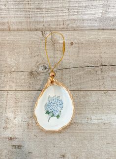 an ornament shaped like a flower on a wooden surface with a gold chain