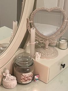 a vanity with a mirror, candle and other items on it