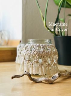 a jar that is sitting on top of a table next to a potted plant