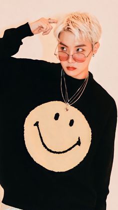 a woman wearing a black sweater with a smiley face on it