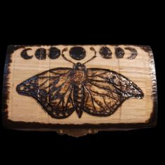 a close up of a wooden object with a butterfly on it's back end