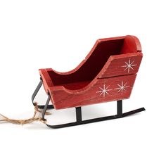 a wooden sleigh with snowflakes on it and rope attached to the sled