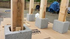 some concrete blocks are sitting in the middle of a construction area with wood posts and blue tarp