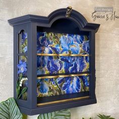 a blue cabinet with flowers painted on it