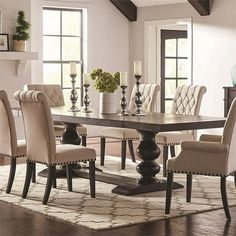 a dining room table with chairs around it and a rug on the floor next to it