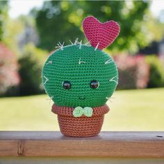 a crocheted cactus sitting on top of a wooden table