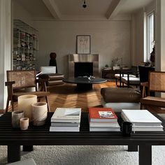 a living room filled with lots of furniture and books on top of a coffee table