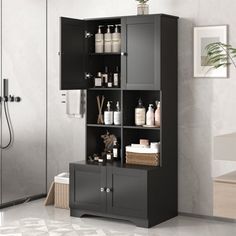 a bathroom with a black cabinet and white tile flooring next to a walk in shower