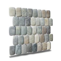 a wall sculpture made out of rocks on the side of a white wall with grey and gray colors