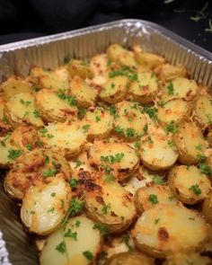 a pan filled with potatoes covered in cheese and parsley