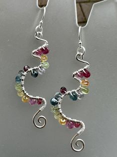 These gorgeous sterling earrings laden in colorful gemstones are reminiscent of vines, new birth, awakening, and longing for spring! The sterling frames are hand shaped in a unique abstract swirling pattern, and hammered for a shimmery texture. Gemstones wrapped in sterling wire add more sparkle to these frames. Finished with sterling ear wires and components.  Gemstones include: Spinel Sapphire Kyanite Tanzanite  Peridot Topaz Citrine Excellent gift idea for that free spirited friend or family Whimsical Multicolor Sterling Silver Jewelry, Multicolor Teardrop Whimsical Jewelry, Artsy Multicolor Sterling Silver Jewelry, Artsy Sterling Silver Multicolor Jewelry, Multicolor Wire Wrapped Sterling Silver Earrings, Whimsical Multicolor Wire Wrapped Jewelry, Wire Earrings Handmade, New Birth, Wire Jewelry Patterns