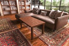 a living room filled with lots of furniture and bookshelves next to a window