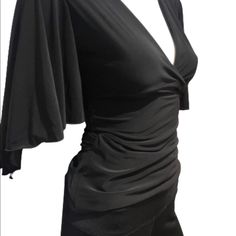 This New With Tags Wrap Blouse Has A Hook Closure To Keep Busy In Place And Long Drape Tie, Gorgeous Flutter Sleeves For Eye Catching Spins And Shines On The Dance Floor. Soft Black Material Complements Any Skirt Or Pants. Excellent Day To Night Staple. Elegant Party Blouse With Draped Sleeves, Elegant Party Top With Draped Sleeves, Elegant Fitted Tops With Draped Sleeves, Fitted Formal Blouse With Draped Sleeves, Fitted Blouse With Draped Sleeves For Formal Occasions, Formal Fitted Blouse With Draped Sleeves, Elegant Draped Blouse For Party, Chic Black Draped Blouse, Elegant Black Draped Blouse