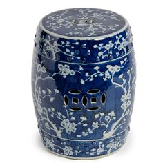 a blue and white ceramic garden stool with flowers on the outside, in front of a white background